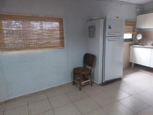 eine Küche mit einem Stuhl und einem Kühlschrank in der Unterkunft Cardozo House Monoambiente acogedor y familiar in Villa Dolores