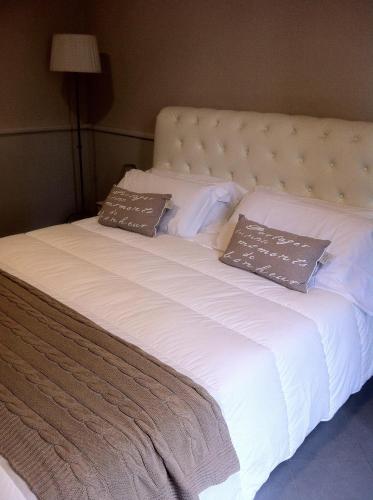 a large white bed with two pillows on it at B&B Le Grazie in Bergamo