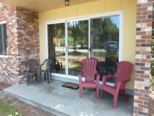 three chairs and a table in front of a window at Atlantic Breeze by Jekyll Realty in Jekyll Island