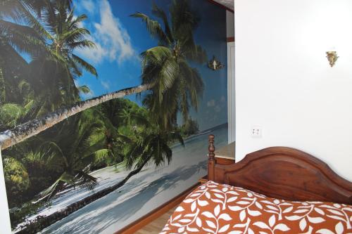 a bedroom with a mural of a beach and palm trees at Pensão França in Porto