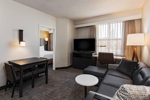 a living room with a couch and a desk in a hotel room at Residence Inn Louisville Downtown in Louisville