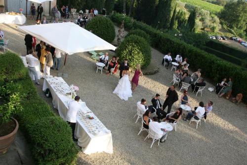 a bride and groom standing under a white umbrella at a wedding at Fattoria di Mandri in Reggello