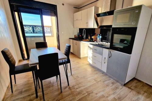 a kitchen with a table and chairs and a dining room at F4 vue sur mer in Oran