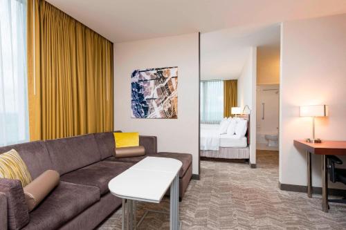 a living room with a couch and a bedroom at SpringHill Suites by Marriott Chicago O'Hare in Rosemont