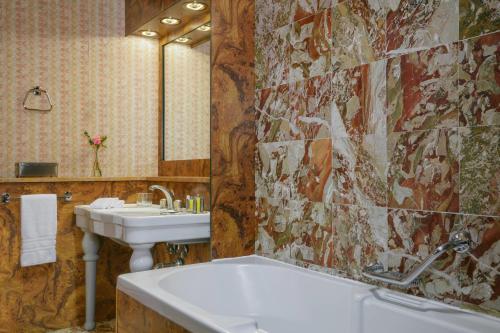 uma casa de banho com um lavatório e uma banheira e um lavatório em Milan Marriott Hotel em Milão