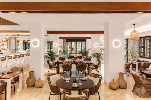 a restaurant with tables and chairs and a bar at Ajman Saray, a Luxury Collection Resort, Ajman in Ajman
