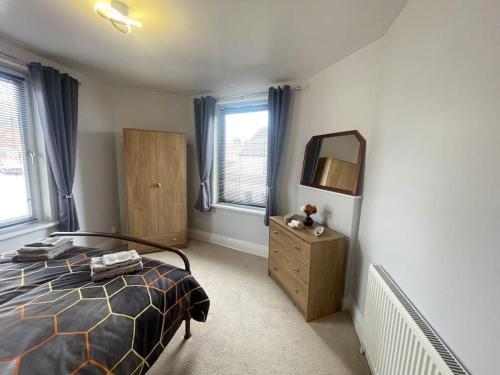a bedroom with a bed and a mirror and a dresser at Beanies LorneStreet Four Bed House in Swindon