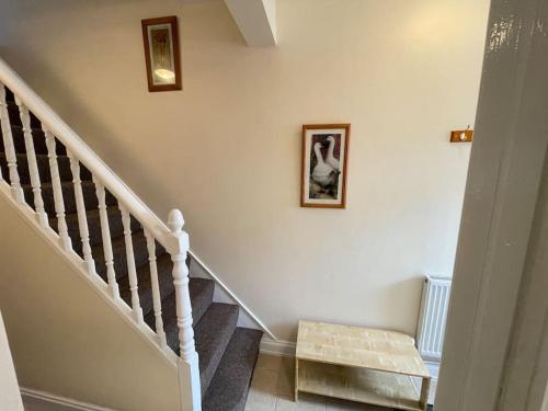 a staircase with two pictures on the wall and a stair case at Beanies LorneStreet Four Bed House in Swindon