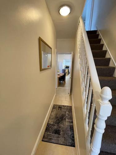 a hallway with a staircase with a rug on the floor at Beanies LorneStreet Four Bed House in Swindon