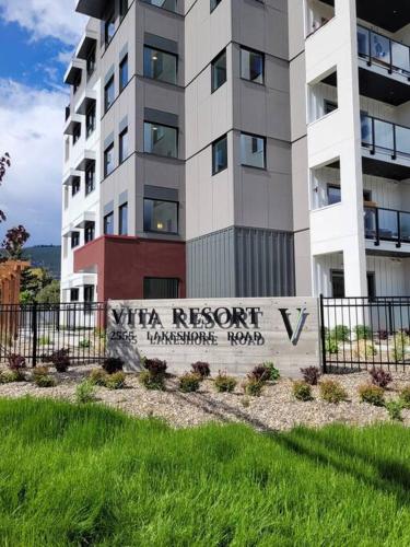 a tall apartment building with a sign in front of it at Lakeside studio with pool in Vernon