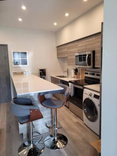 a kitchen with a counter and two bar stools at Lakeside studio with pool in Vernon