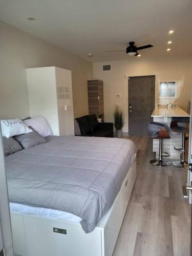 a bedroom with a large bed and a desk at Lakeside studio with pool in Vernon