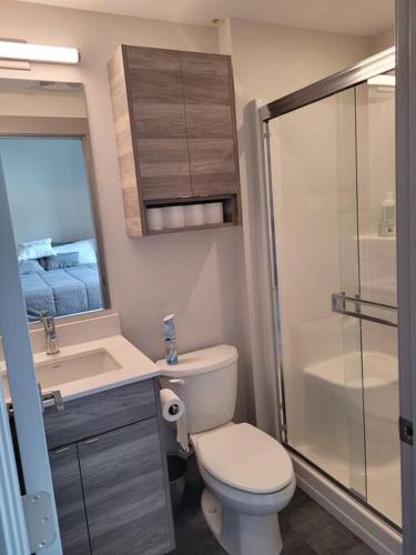 a bathroom with a toilet and a sink and a shower at Lakeside studio with pool in Vernon