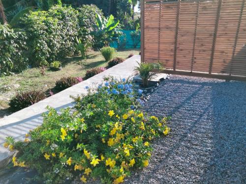 um jardim com flores amarelas e uma cerca de madeira em Les Gîtes de Bibine Coin calme et tranquille em Rabi