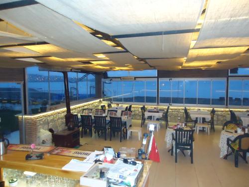 a restaurant with tables and chairs on a balcony at Bells Motel in Seferihisar