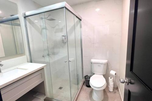 uma casa de banho com um WC e uma cabina de duche em vidro. em Luxury 2BR Condo Rosarito (D) em Rosarito
