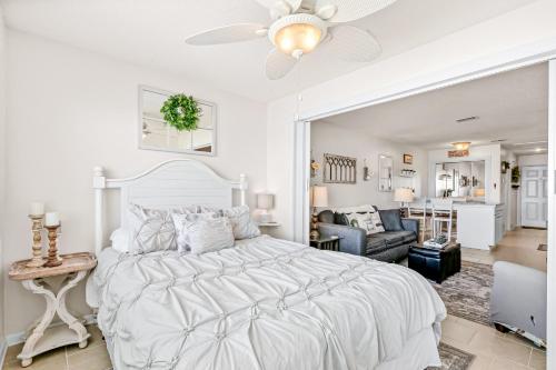 a white bedroom with a bed and a living room at Sunset Harbor Palms 1-308 in Navarre