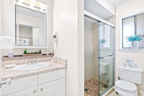 a white bathroom with a toilet and a sink at Sunset Harbor Palms 1-308 in Navarre