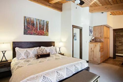 a bedroom with a large bed and a painting on the wall at Snowmass Village, 3 Bedroom at the Enclave - Ski-in Ski-out with Airport Transfers in Snowmass Village