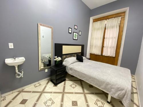 a bedroom with a bed and a sink and a mirror at WHOST Hotel y Hostal in Mexico City