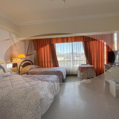 pokój hotelowy z 2 łóżkami i oknem w obiekcie Hotel Kokusai w mieście Cochabamba