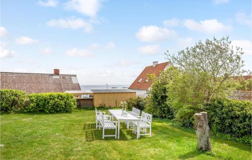 a table and chairs in the yard of a house at 1 Bedroom Gorgeous Apartment In Svaneke in Svaneke