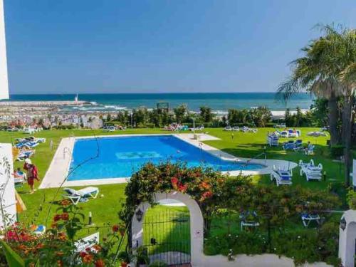 a resort with a swimming pool and the ocean at Cabopino Beach & Marina Apartment in Marbella