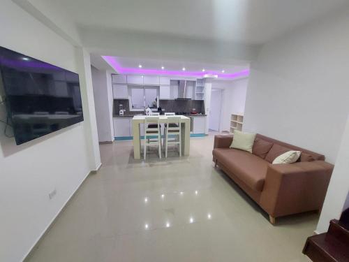 a living room with a brown couch and a kitchen at Yaque Suite in El Yaque