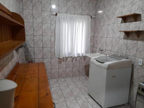 a small bathroom with a toilet and a sink at Hospedagem Tia Marli in Pomerode