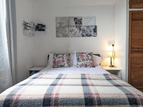 a bedroom with a bed with a plaid blanket at Whitchurch 1 Bedroom Apartment in Cardiff