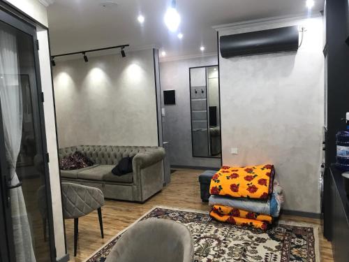 sala de estar con sofá y espejo en apartment seven A, en Tashkent
