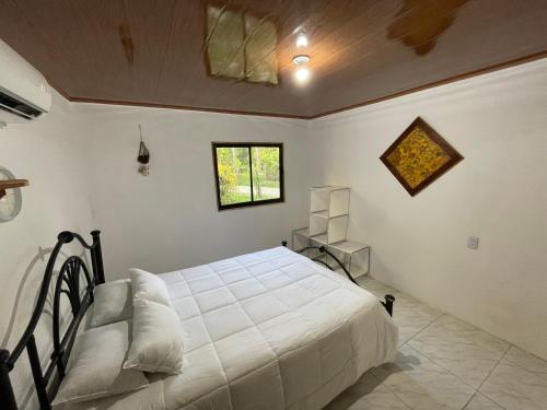 Un dormitorio con una gran cama blanca y una ventana en Sweet Home en Cabuya