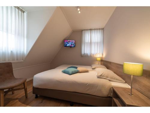 ein Schlafzimmer mit einem großen Bett mit in der Unterkunft Detached family friendly villa in the Oosterschelde National Park in Colijnsplaat