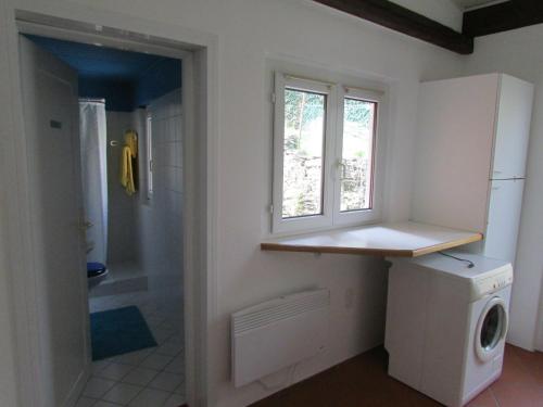eine Waschküche mit einer Waschmaschine und einem Fenster in der Unterkunft Casa Sott Al Sass in Ascona