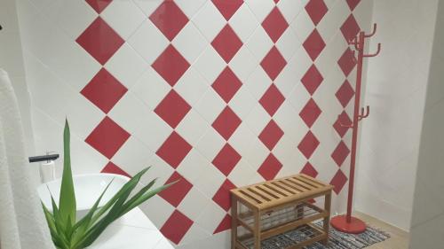 uma casa de banho com uma parede xadrez vermelha e branca em St@y Tunes em Albufeira