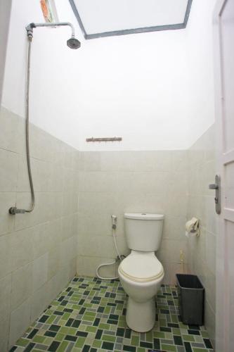 a bathroom with a toilet and a shower at Manta Manta Guesthouse in Labuan Bajo