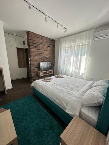 a bedroom with a large bed with a green rug at DREAM apartments in Niš