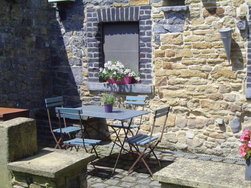 a table and chairs in front of a stone wall at Tranquil Home in Tinlot in Tinlot