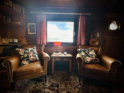 a room with two chairs and a table and a window at Rustic Chalet ultimate relaxation in the forest in Sourbrodt