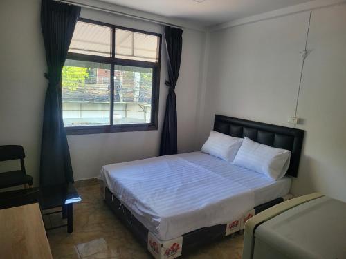 een slaapkamer met een bed en een raam bij THE NEST in Pattaya