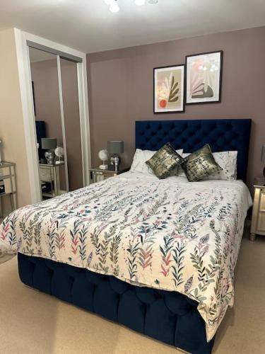 um quarto com uma cama grande e uma cabeceira azul em Beautiful 3 Bedroom Duplex Apartment with Balcony em North Woolwich