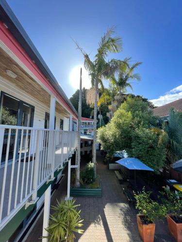 un balcón de una casa con árboles y plantas en Peppertree Lodge & Backpackers en Paihia