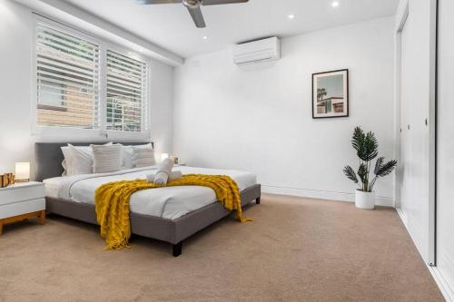 a bedroom with a bed with a yellow blanket on it at Tranquil apartment in the city in Newcastle