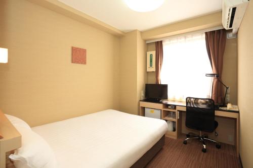 a hotel room with a bed and a desk and a computer at Smile Hotel Otsu Seta in Otsu