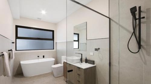 a bathroom with a toilet and a sink and a shower at Villa Marina in Lakes Entrance
