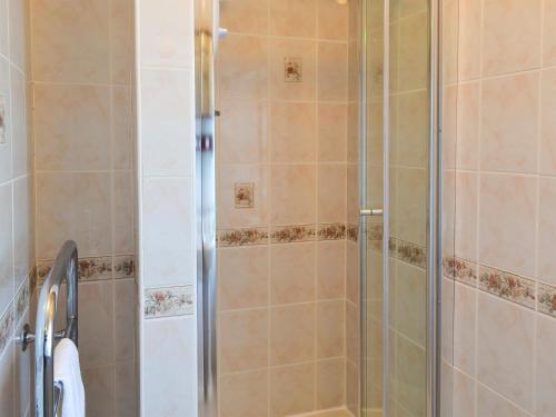 een douche met een glazen deur in de badkamer bij Primrose Villa in Rosedale Abbey