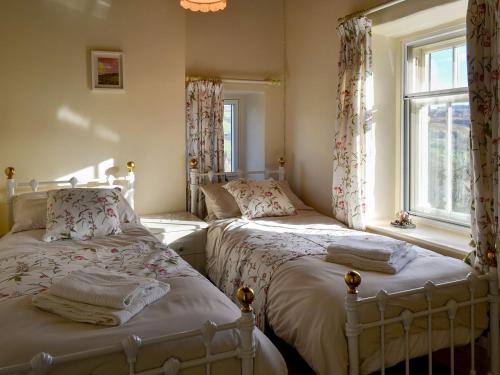 1 dormitorio con 2 camas y ventana en Primrose Villa, en Rosedale Abbey