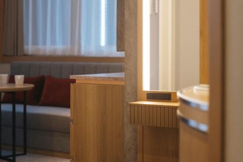 a room with a couch and a table and a mirror at Hotel JAL City Haneda Tokyo in Tokyo