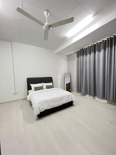 1 dormitorio blanco con 1 cama y ventilador de techo en K.U Homestay, en Kota Bharu