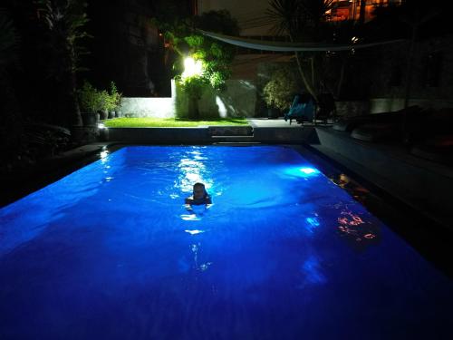 a person swimming in a pool at night at Baan Heaven / Patong Beach Pool Villa Sleeps up to 15 in Patong Beach